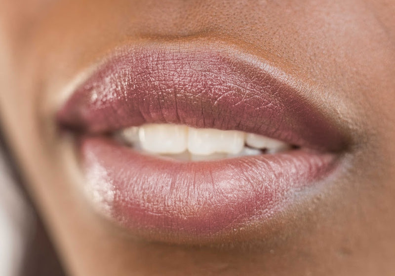 Wine burgundy tinted lip balm applied to model's lips