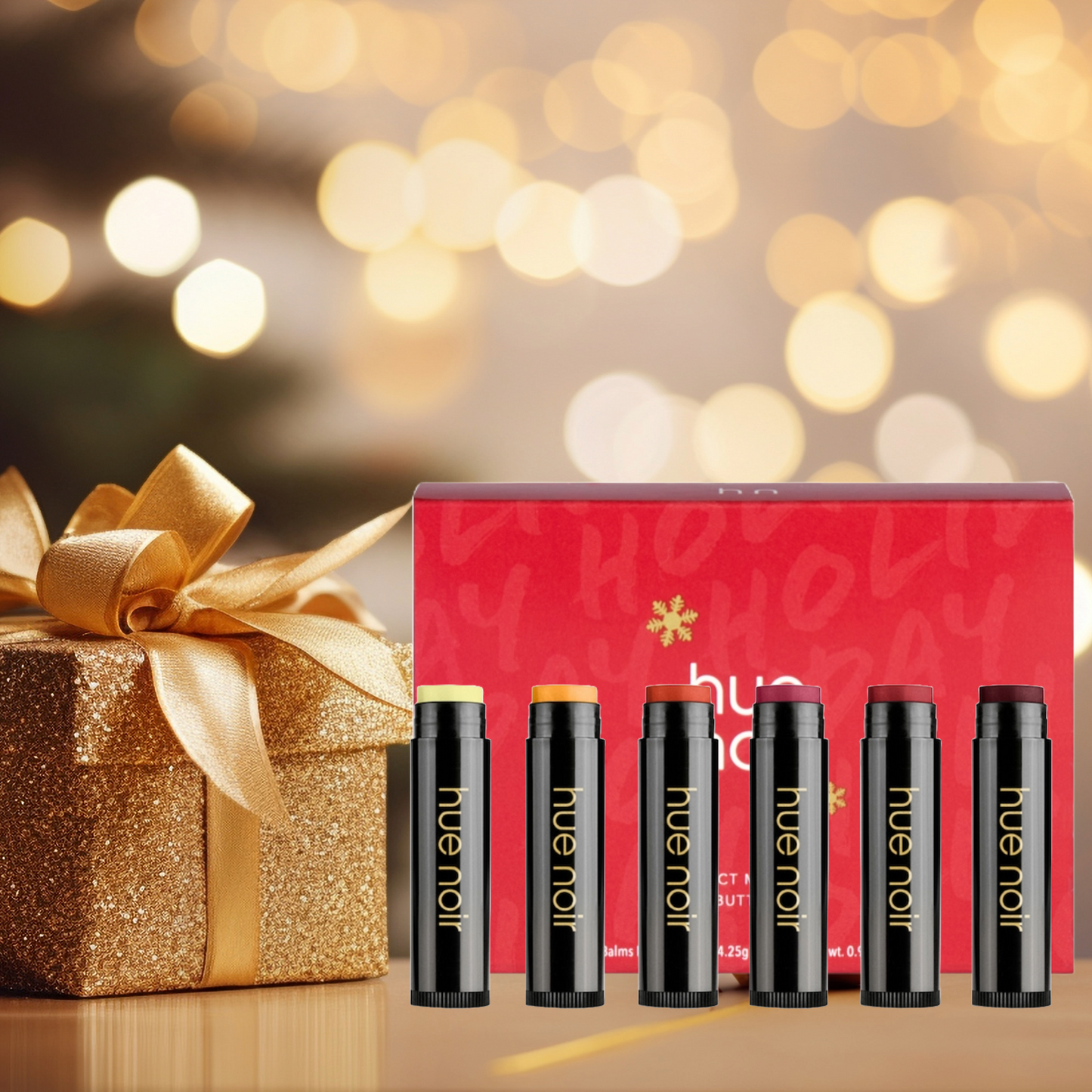 Perfect Moisture Lip Balm Set | Holiday Party Balm in red packaging with a gold box, placed on a shimmery golden background