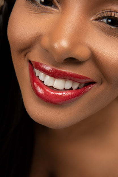 A model wearing the Hue Noir Red Crimson Perfect Pout Lip Combo, showcasing its bold, rich red shade with a smooth finish.