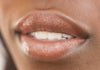Copper tinted lip balm applied to model's lips showing hint of copper color and moisturization level