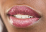 Ruby red tinted lip balm applied to model's lips
